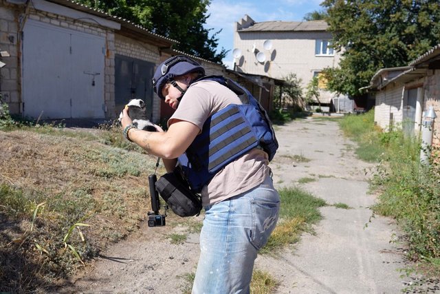 Журналістка Суспільне Дніпро Олеся Приходько тримає на руках цуценя, яке знайшли на покинутому подвір'ї. Суспільне Дніпро Мог погибнуть без помощи: из прифронтовой Васильковки журналисты спасли трехнедельного щенка