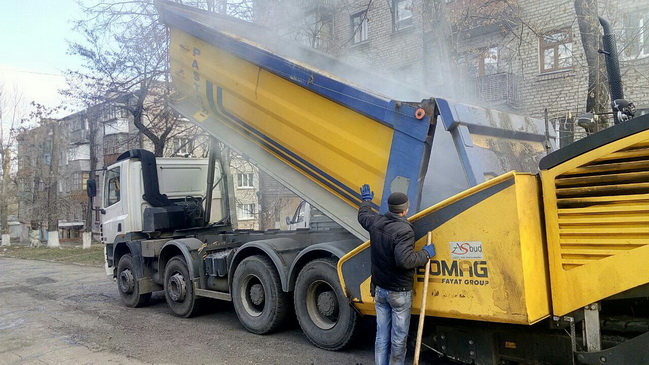 На прохання мешканців мікрорайону Черемушки в Кам`янському ремонтують чергову розбиту дорогу